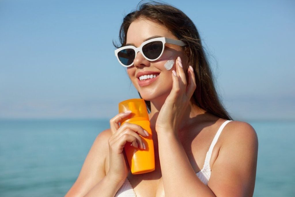 Applying broad spectrum sunscreen SPF 30 on face for sun protection